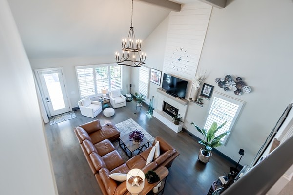 living room with a wealth of natural light, dark hardwood / wood-style flooring, and high vaulted ceiling