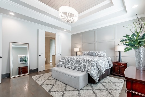 bedroom featuring dark wood-type flooring, crown molding, and a tray ceiling