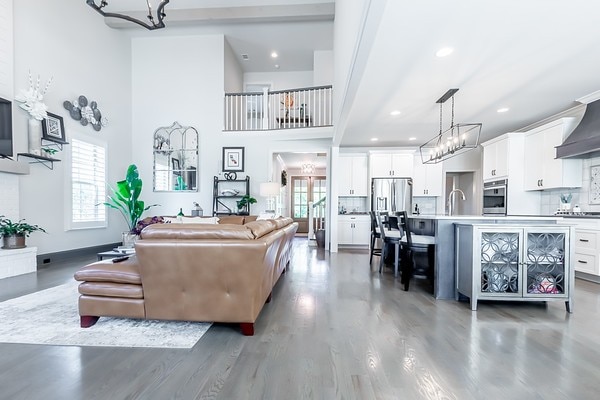 living room featuring sink, dark wood-type flooring, and a high ceiling