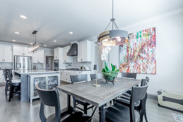 dining space featuring hardwood / wood-style floors, ornamental molding, and sink