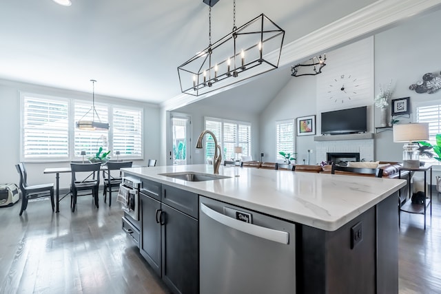 kitchen with stainless steel dishwasher, sink, a kitchen island with sink, and a wealth of natural light