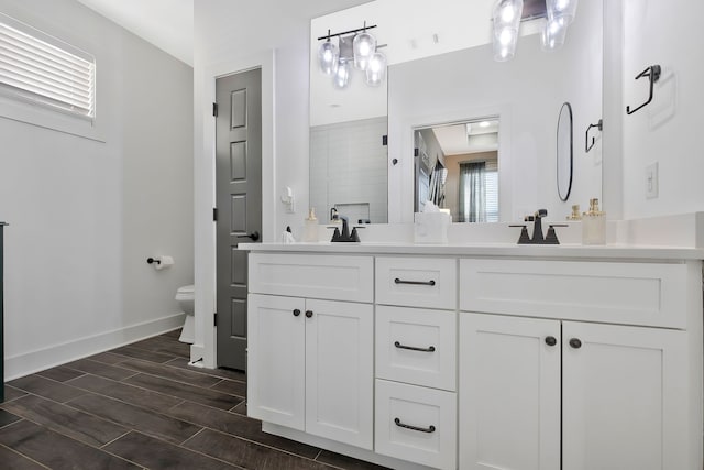 bathroom featuring toilet, a shower, vanity, and wood-type flooring