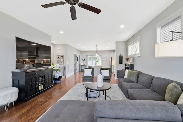 living room with dark hardwood / wood-style floors and ceiling fan