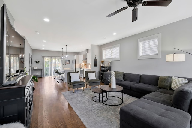 living room featuring dark wood-type flooring and ceiling fan