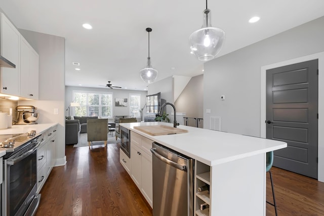 kitchen featuring white cabinets, a kitchen island with sink, stainless steel appliances, and pendant lighting