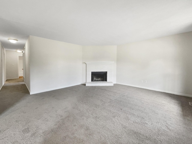 unfurnished living room with a fireplace and carpet floors