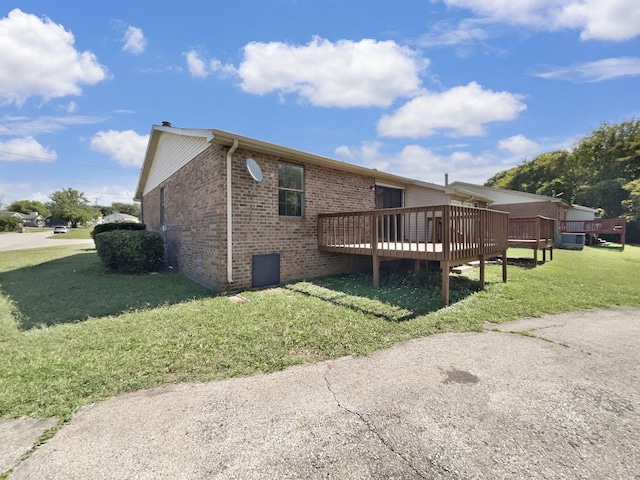 view of property exterior with a yard and a deck