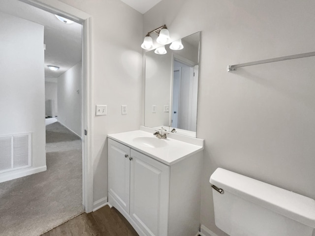 bathroom with vanity, toilet, and wood-type flooring