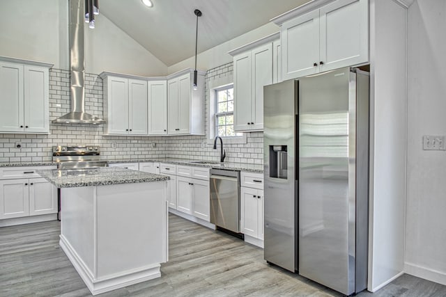 kitchen with backsplash, appliances with stainless steel finishes, light stone countertops, vaulted ceiling, and pendant lighting