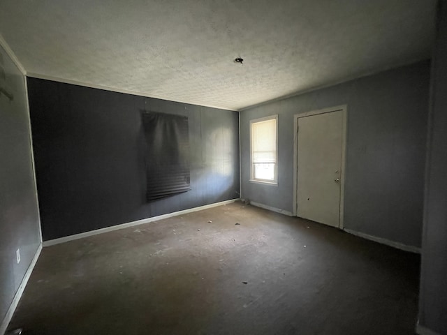 unfurnished room with a textured ceiling and concrete flooring