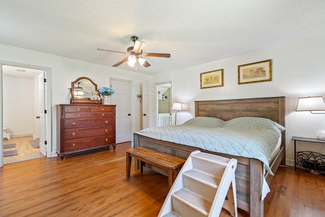 bedroom featuring connected bathroom, hardwood / wood-style flooring, and ceiling fan