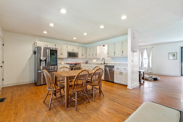 dining area with light hardwood / wood-style floors and sink