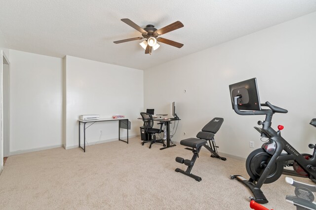 workout area with ceiling fan, light colored carpet, and a textured ceiling