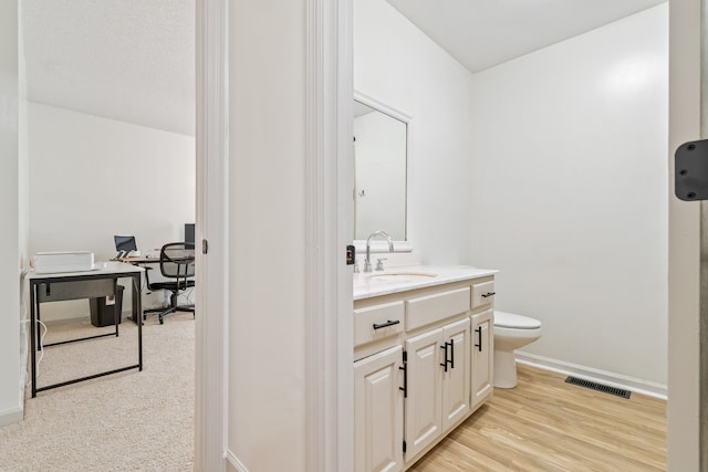 bathroom with vanity, wood-type flooring, and toilet