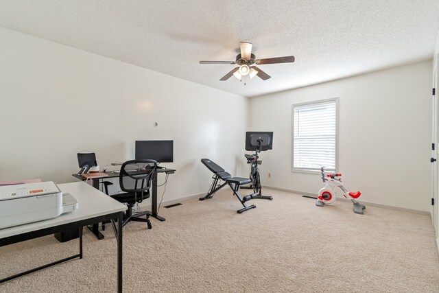 office space featuring light carpet, a textured ceiling, and ceiling fan