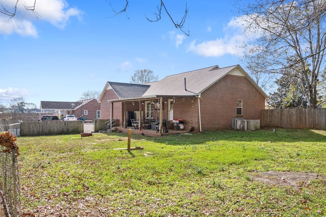 rear view of house featuring central AC unit, a patio area, and a yard