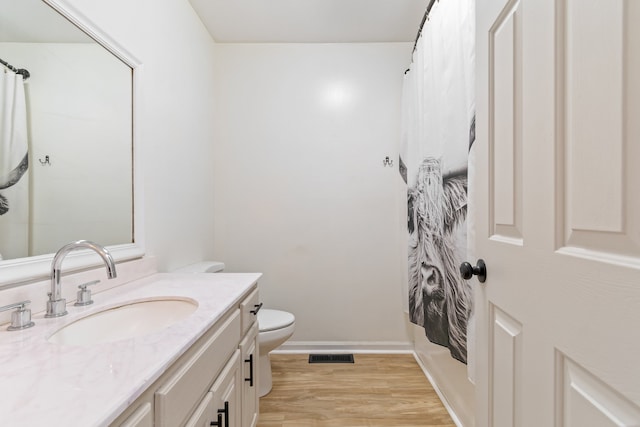 bathroom with hardwood / wood-style floors, vanity, toilet, and a shower with curtain