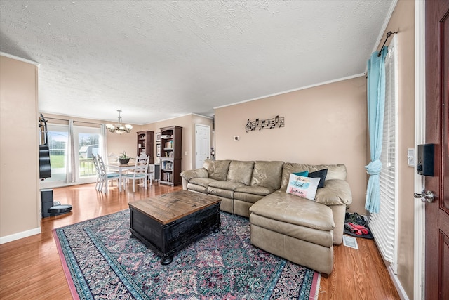 living room featuring a notable chandelier, hardwood / wood-style flooring, and a textured ceiling