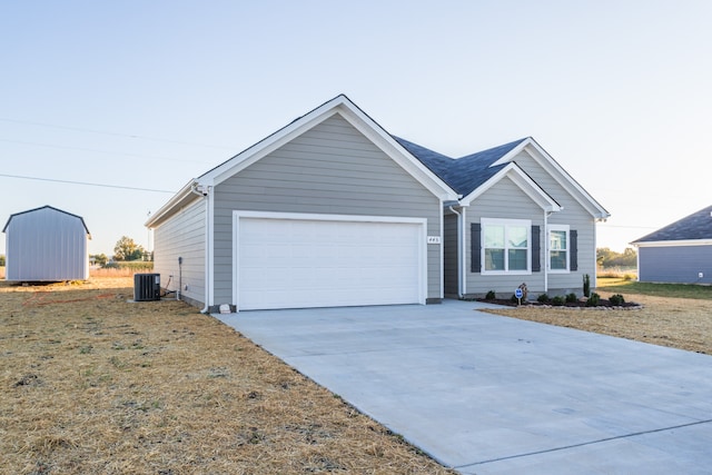 ranch-style home with a garage, a shed, and central air condition unit