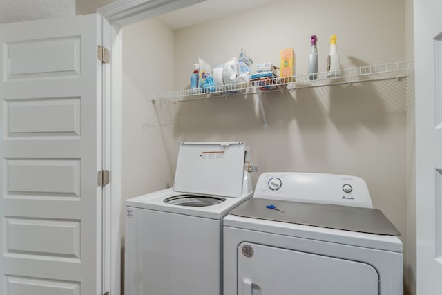 laundry room with washer and clothes dryer and a textured ceiling