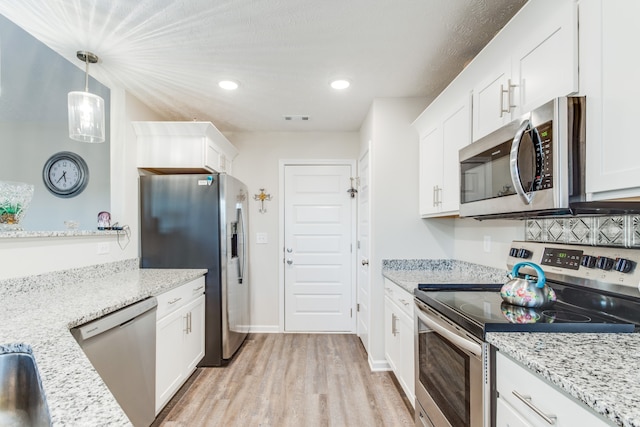 kitchen featuring white cabinetry, appliances with stainless steel finishes, and pendant lighting