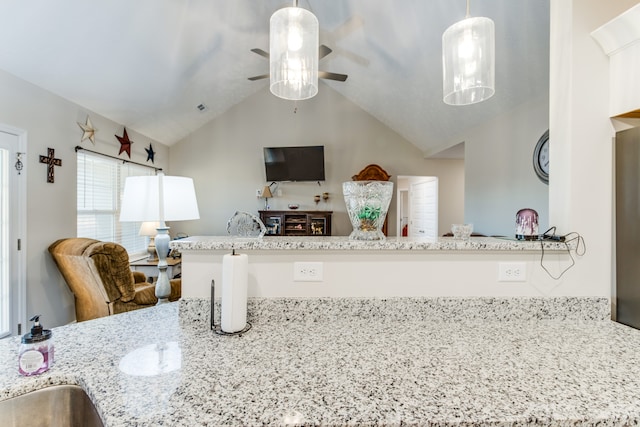 kitchen featuring kitchen peninsula, light stone countertops, decorative light fixtures, and lofted ceiling