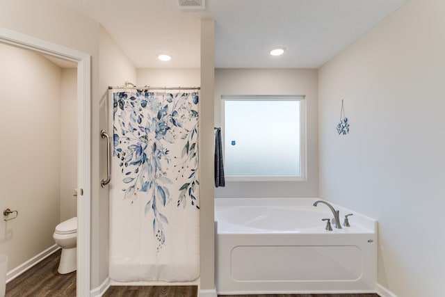 bathroom with toilet, shower with separate bathtub, and hardwood / wood-style flooring