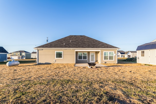 rear view of property featuring a patio and a shed