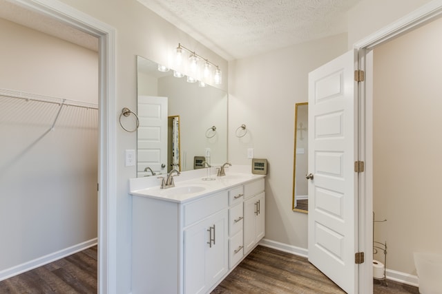 bathroom featuring vanity, a textured ceiling, and wood-type flooring