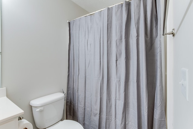 bathroom featuring vanity, a shower with shower curtain, and toilet