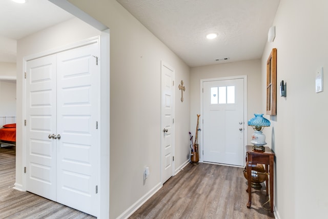 foyer with a textured ceiling and wood-type flooring