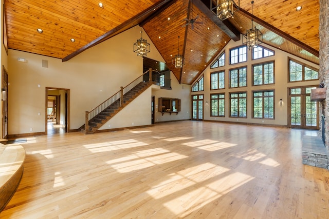 unfurnished living room with beamed ceiling, light wood-type flooring, wood ceiling, and high vaulted ceiling