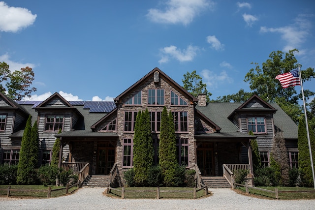 log cabin featuring covered porch and solar panels