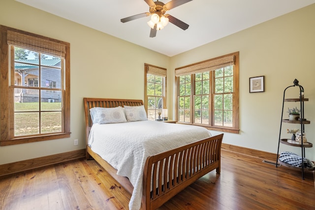 bedroom featuring multiple windows, ceiling fan, and wood-type flooring