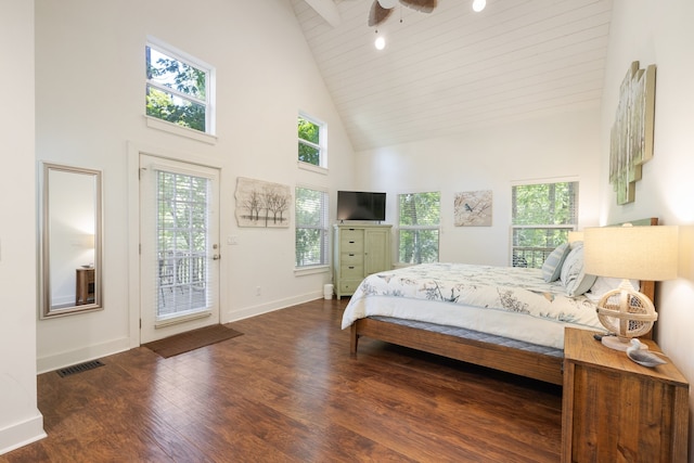 bedroom featuring dark wood-type flooring, high vaulted ceiling, and multiple windows