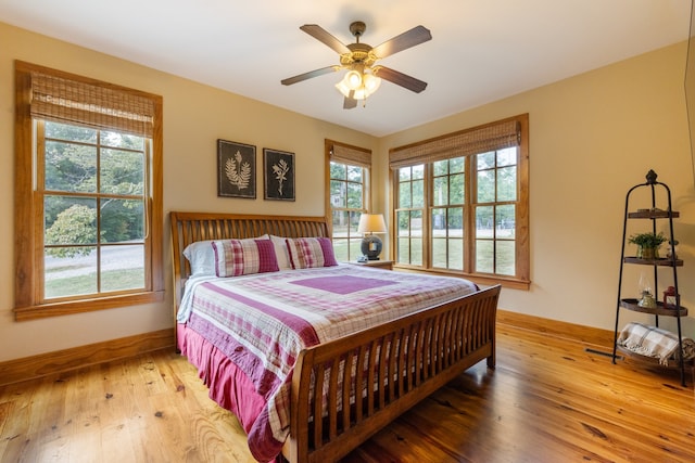 bedroom featuring multiple windows, ceiling fan, and wood-type flooring