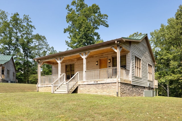 view of front of property featuring a front yard, a porch, and central AC unit