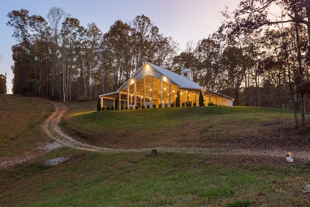 property exterior at dusk featuring a lawn