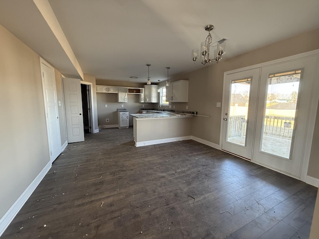 kitchen with dark hardwood / wood-style floors, a wealth of natural light, decorative light fixtures, white cabinetry, and kitchen peninsula