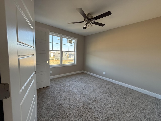 carpeted spare room featuring ceiling fan