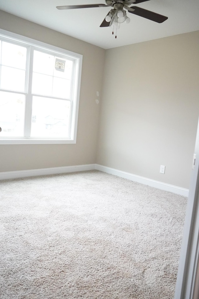 empty room featuring carpet floors, baseboards, and a ceiling fan