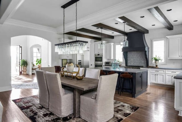 dining space with dark hardwood / wood-style flooring, crown molding, beam ceiling, and a wealth of natural light