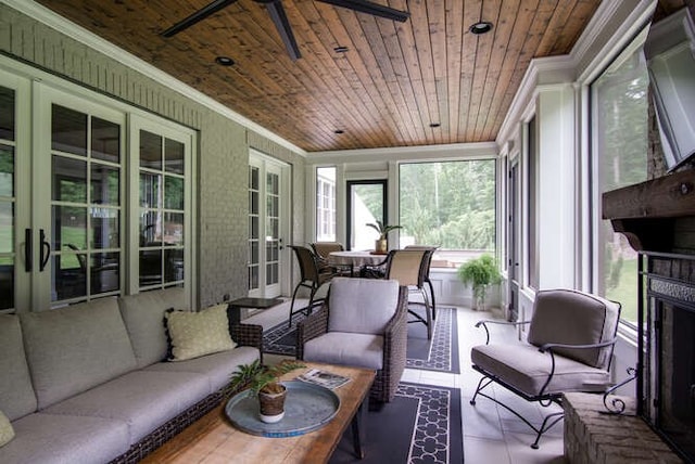 sunroom with french doors, wood ceiling, a brick fireplace, and ceiling fan