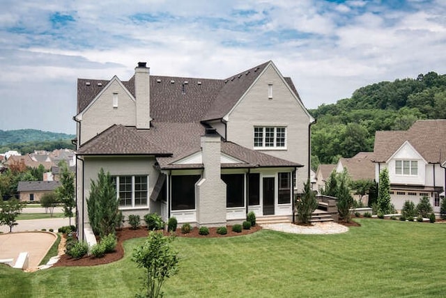 view of front of house featuring a sunroom, a front lawn, and a garage