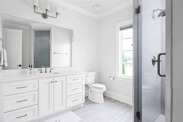 bathroom featuring vanity, an enclosed shower, ornamental molding, and toilet