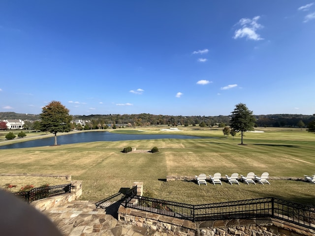 surrounding community featuring a lawn and a water view