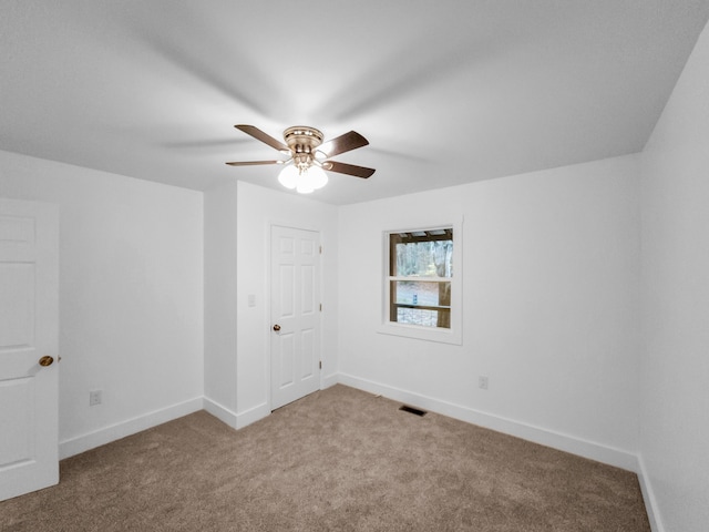 carpeted spare room featuring ceiling fan