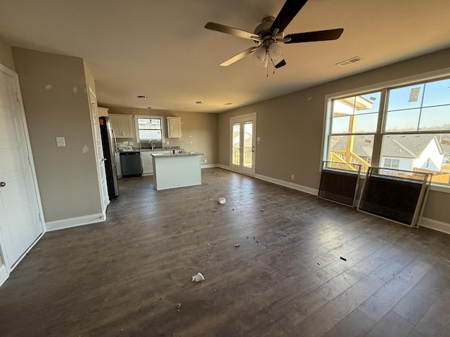 unfurnished living room featuring ceiling fan, dark hardwood / wood-style floors, and sink