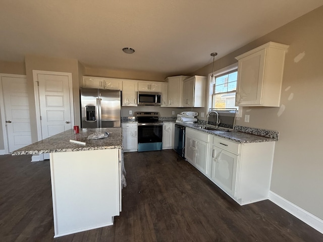 kitchen featuring sink, white cabinetry, decorative light fixtures, stone counters, and stainless steel appliances