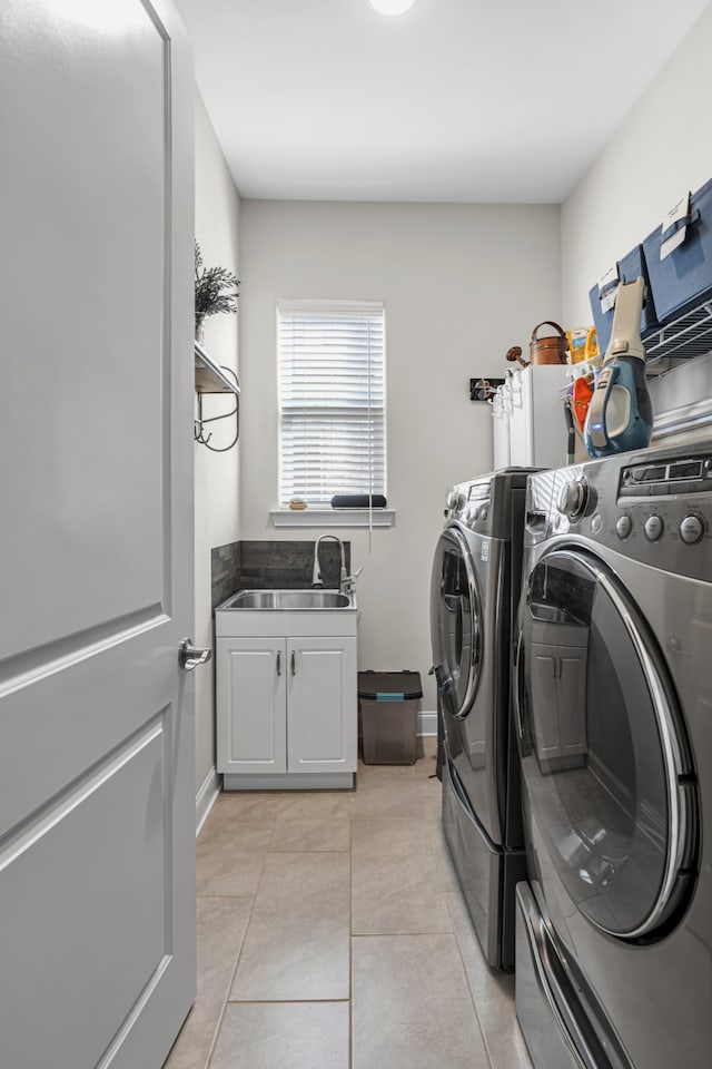 washroom with washer and dryer, light tile patterned flooring, sink, and cabinets